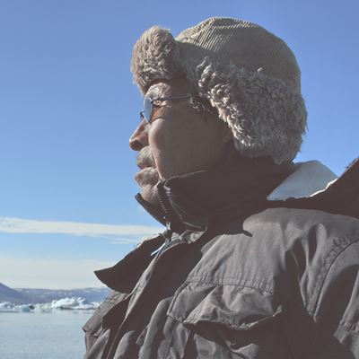 En grønlandsk jæger med smuk natur i baggrunden.