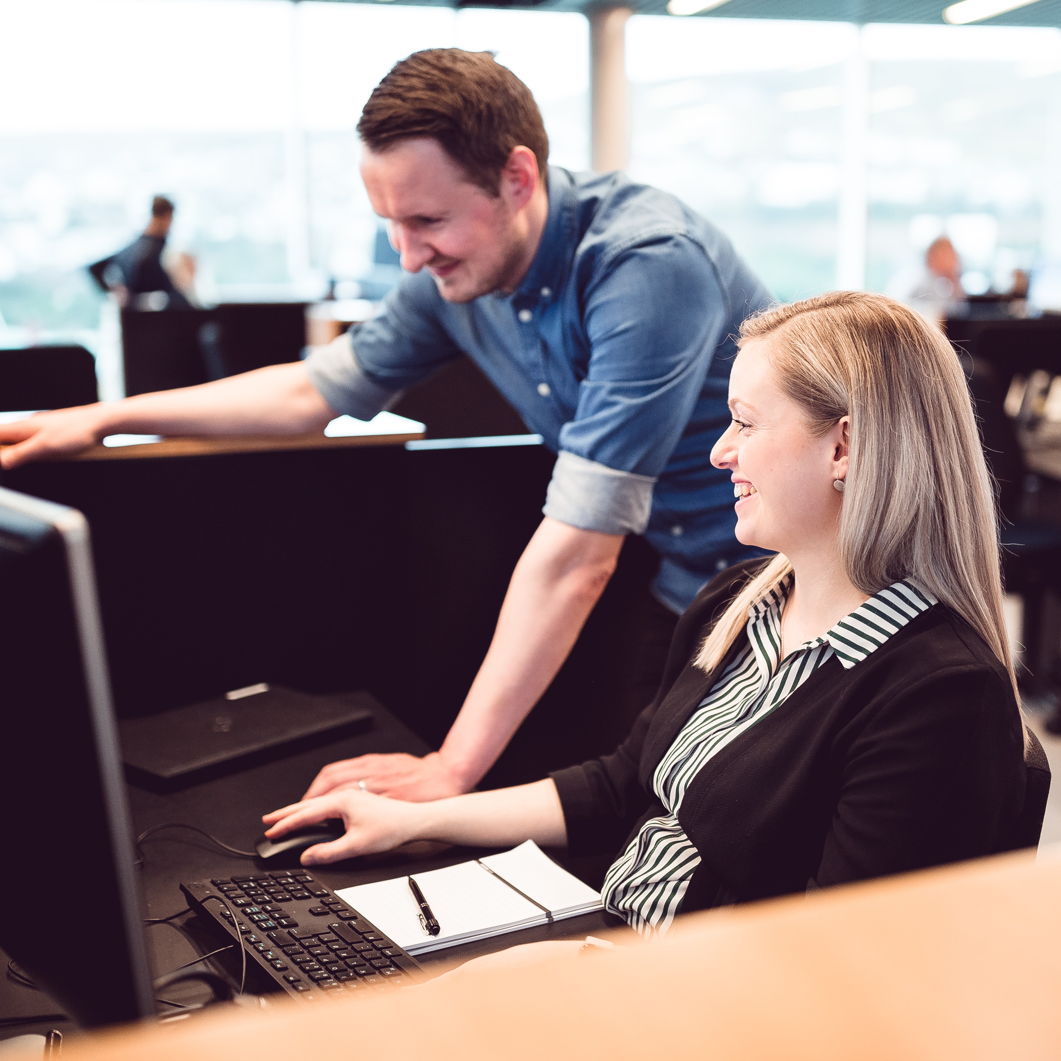 Kollegaer smiler på arbejdet