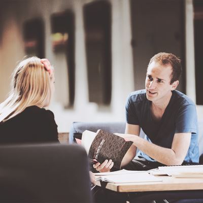 En mandlig og en kvindelig studerende taler sammen om en bog