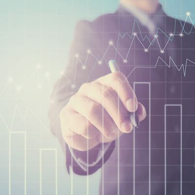 En mand i jakkesæt tegner grafer for aktierkurser op