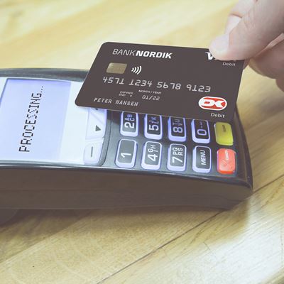 En mand betaler kontaktløst med sit BankNordik dankort