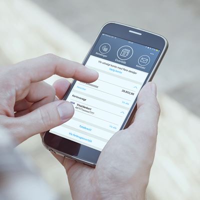 En mand bruger BankNordiks mobilbank på sin smartphone