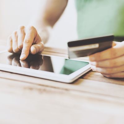 En mand betaler online på sin tablet med sit betalingskort