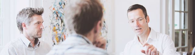 Tre mænd holder morgenmøde