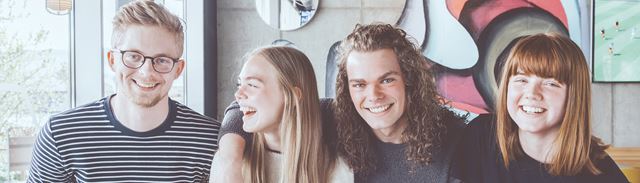 En gruppe unge sider sammen på en café og smiler