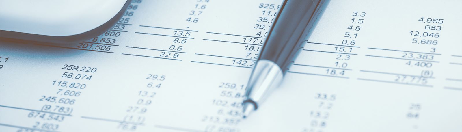 Et budget ligger på et bord sammen med en kuglepen og en lommeregner