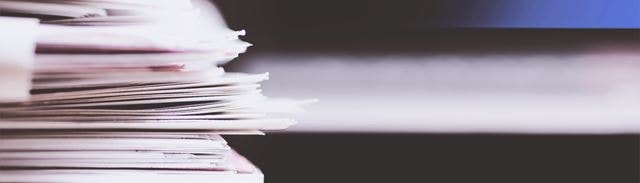 En stak papirer ligger på et bord