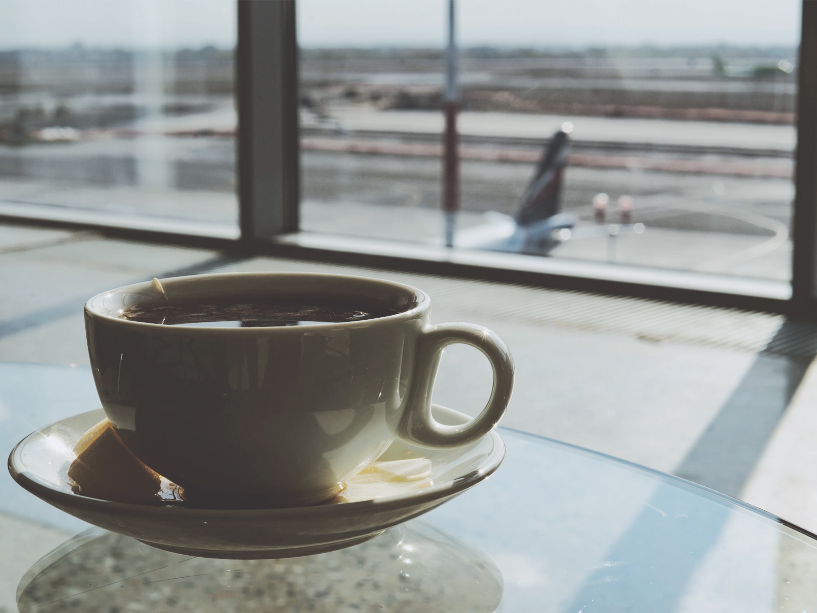 En kop kaffe står på et bord i en lufthavnsterminal