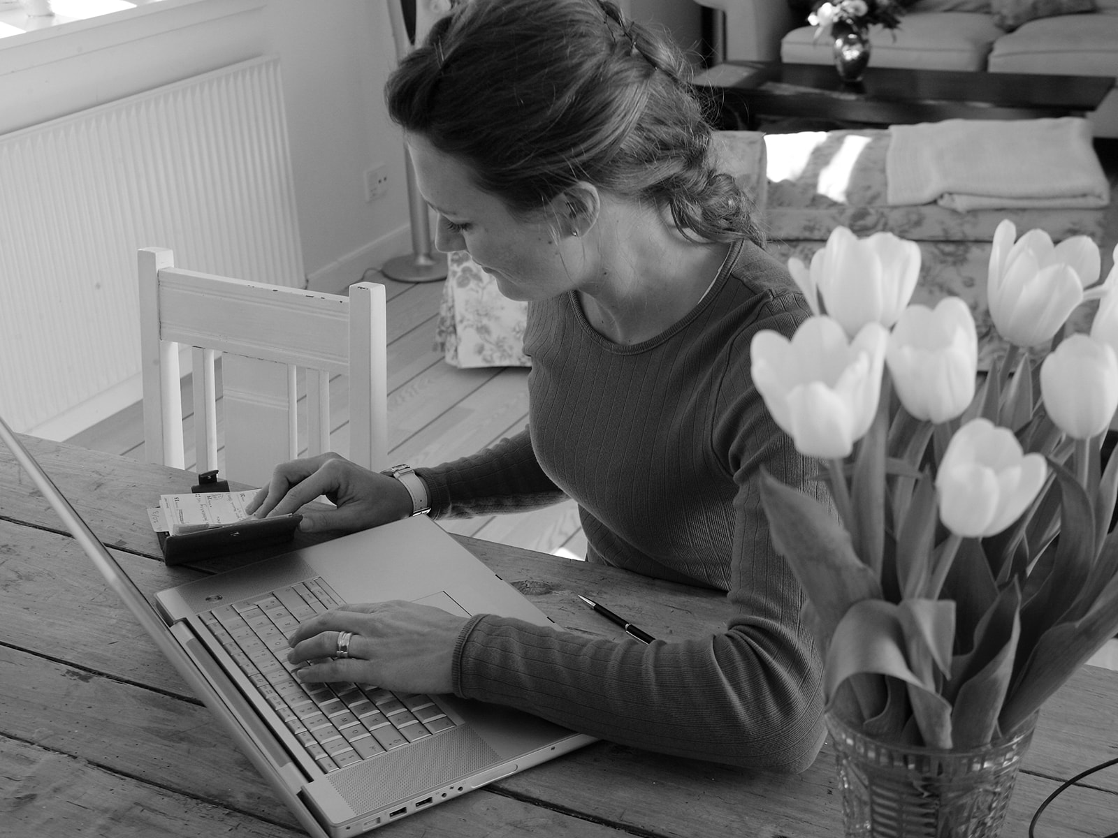 En rødhåret kvinde arbejder ved sin computer