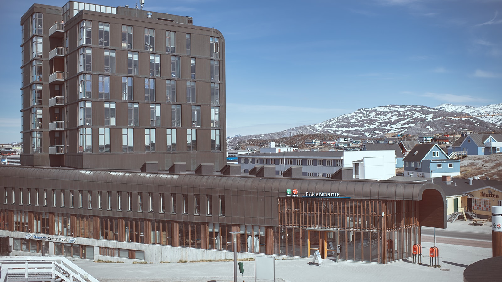 filialen Nuuk med et bjerg i baggrunden.