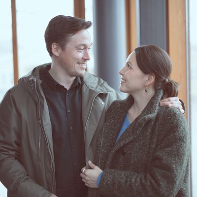 Et par står tæt og kigger smilende på hinanden,