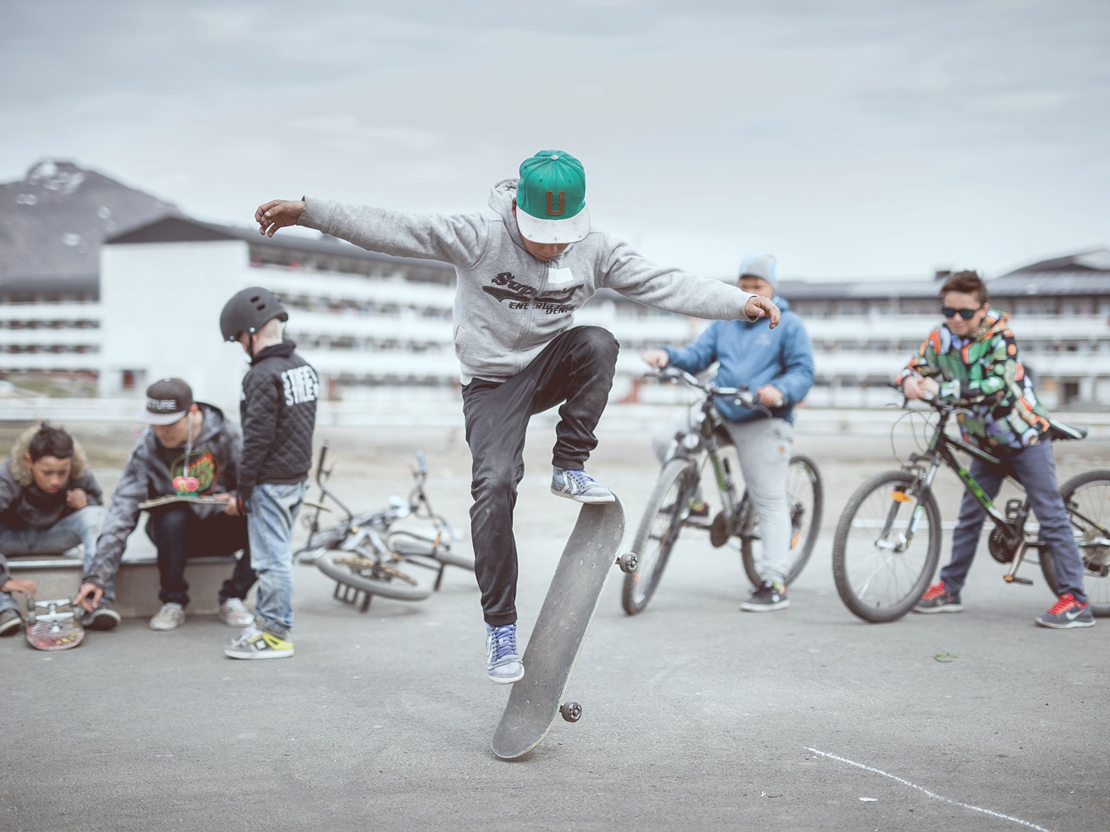Unge drenge hænger ud på en sketarplads ned deres cykler og skateboard. 