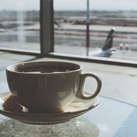 En kop kaffe står på et bord i en lufthavnsterminal
