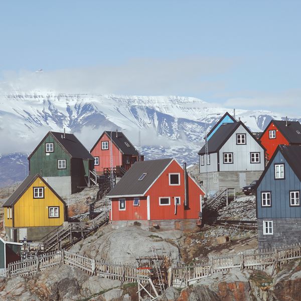 Flere farverige huse på en bakke.