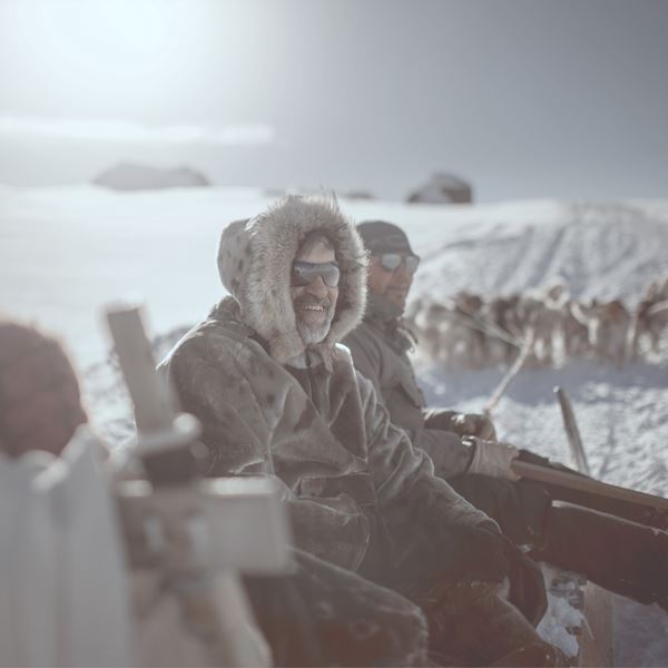 En mand sidder på en hundeslæde.